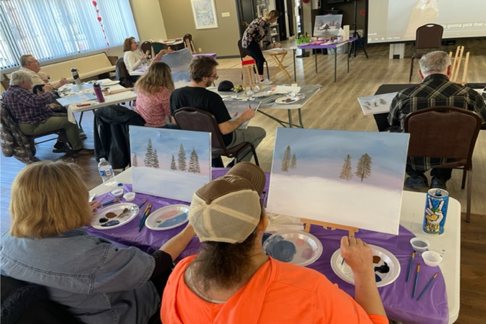 Picture of a group of people sitting at desks painting at the Senior Center